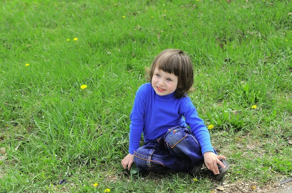 stock image Child in a blue dress on the grass