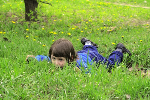 Bambino con un vestito blu sull'erba — Foto Stock