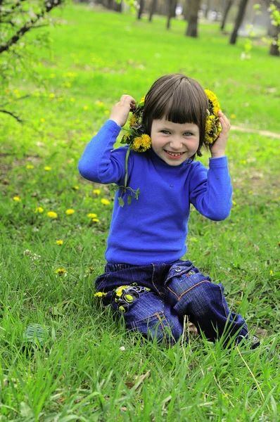Criança em um vestido azul na grama — Fotografia de Stock