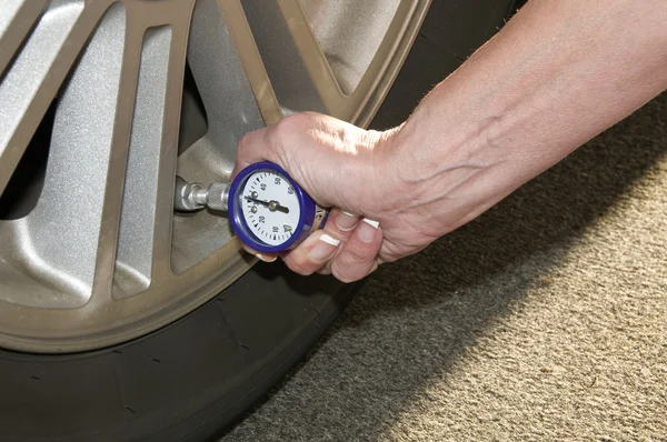 Mulher verificando pneus — Fotografia de Stock