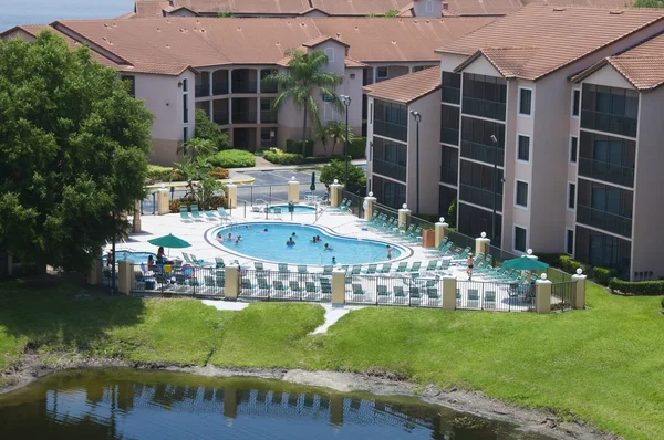 Resort Pool in der Nähe eines Sees, umgeben von Eigentumswohnungen — Stockfoto