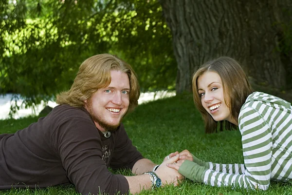 Jovem casal de mãos dadas no parque — Fotografia de Stock