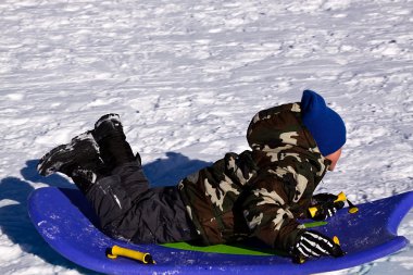 Little Boy Sledding down the Hill clipart