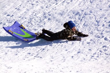 Little Boy Sledding down the Hill clipart