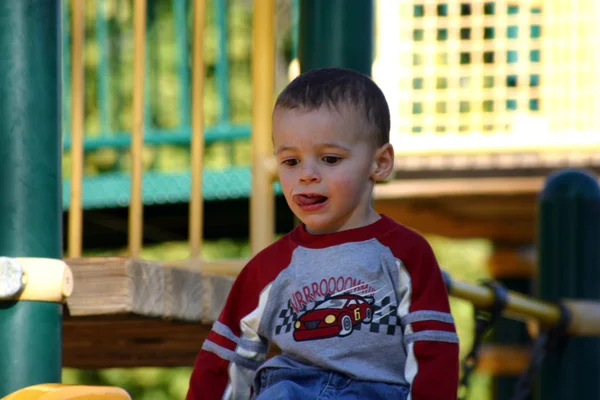 Kleiner Junge sitzt auf dem Schieberegler — Stockfoto