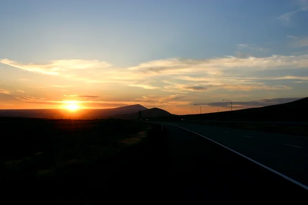 Pôr do sol pela estrada — Fotografia de Stock