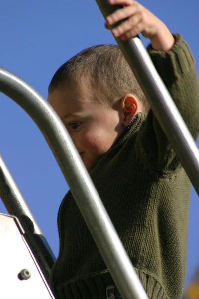 Ребенок вскарабкается на слайдер — стоковое фото