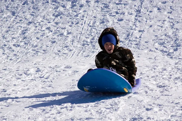 丘を下ってそり滑り少年 — ストック写真