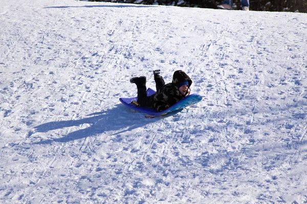 丘を下ってそり滑り少年 — ストック写真