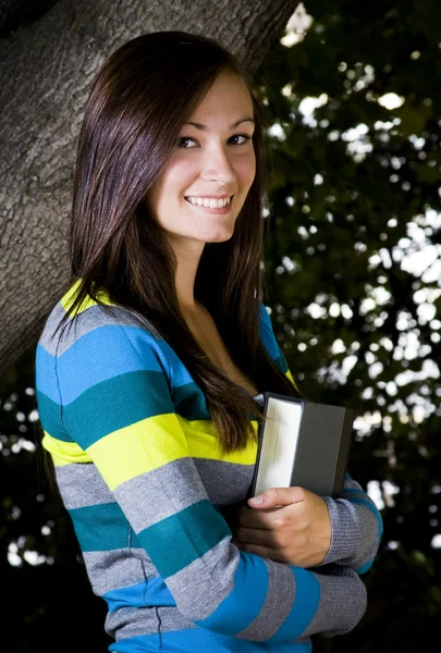 Adolescente bonita segurando um livro — Fotografia de Stock