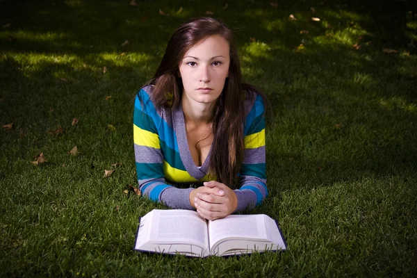 Krásná dívka v parku čtení — Stock fotografie