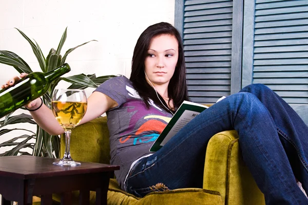 Linda chica bebiendo mientras lee un libro — Foto de Stock