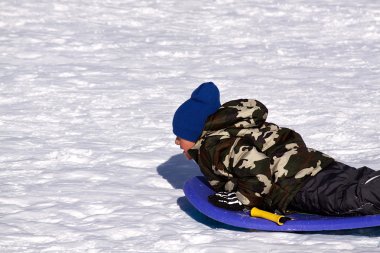 Little Boy Sledding down the Hill clipart