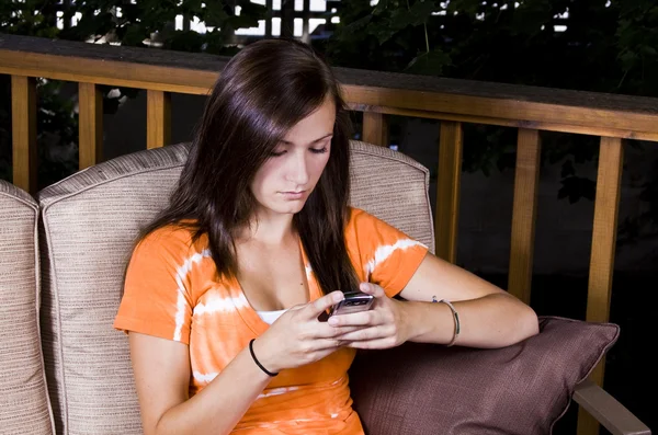 Hermosa chica mensajes de texto en el patio —  Fotos de Stock