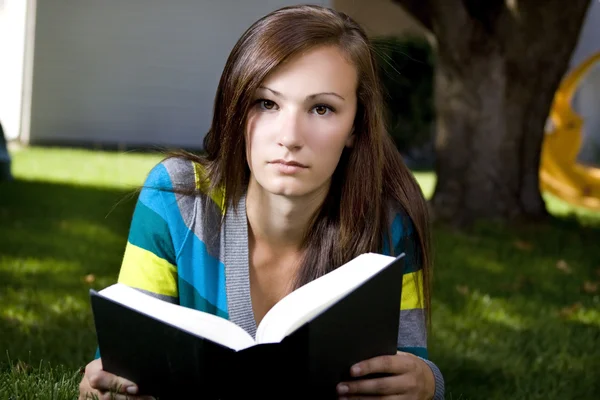 Закройте глаза на женщину, читающую книгу — стоковое фото
