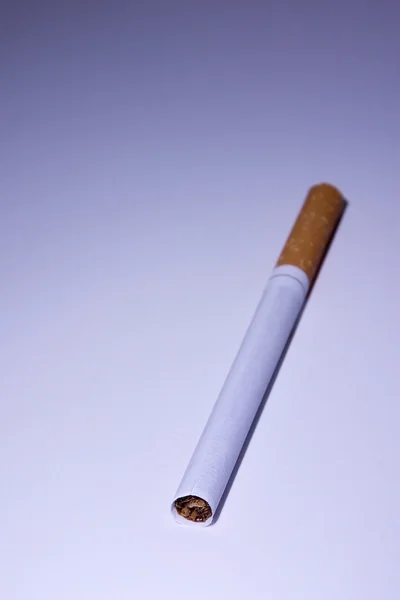 Cigarrillo aislado bajo luz azul — Foto de Stock