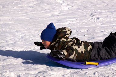 Little Boy Sledding down the Hill clipart