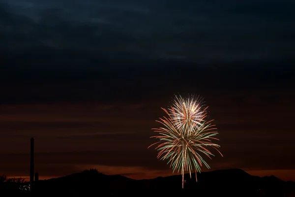 Fogos de artifício no céu durante o pôr do sol — Fotografia de Stock