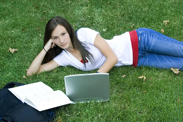 Roztomilé dospívající dívka, kterým se stanoví na trávě — Stock fotografie