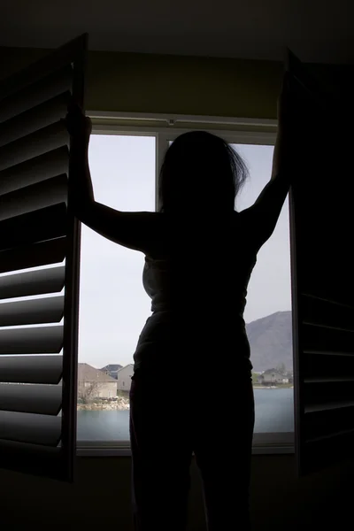 Silhueta de uma mulher pela janela — Fotografia de Stock