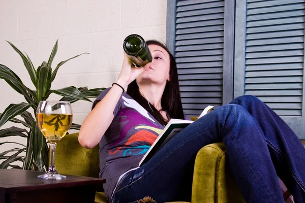 Linda chica bebiendo mientras lee un libro —  Fotos de Stock