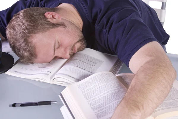 Högskolestudent som sover på hans skrivbord — Stockfoto