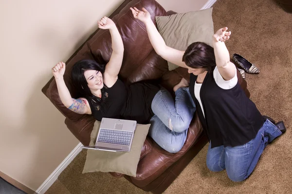 Две девушки на диване совершают покупки в Интернете — стоковое фото