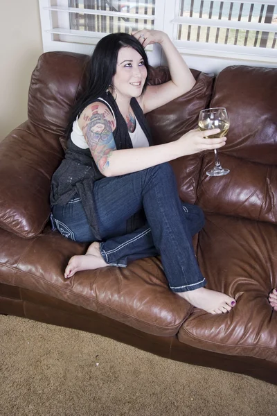 Жінка сидить на дивані — стокове фото