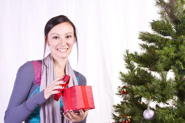 Mooi meisje door de kerstboom — Stockfoto