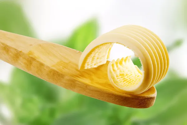 Butter curl on a wooden spoon — Stock Photo, Image