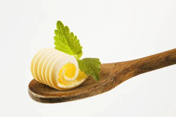 Butter curl on a wooden spoon — Stock Photo, Image