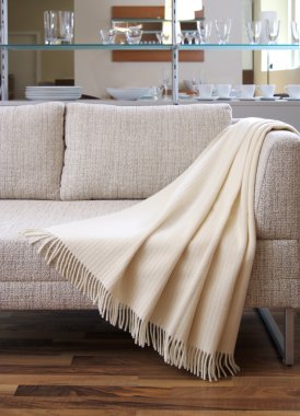 Cream throw draped over a settee clipart