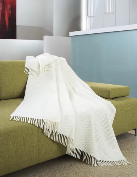 Fehér dobja draped egy kanapé — Stock Fotó
