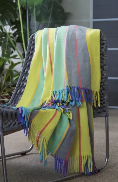 Colourful throw draped over a chair — Stock Photo, Image