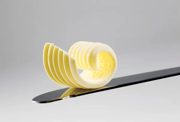 Butter curl on a knife — Stock Photo, Image