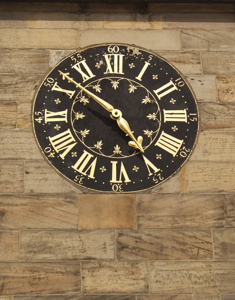 Antiguo reloj dorado en la pared de piedra — Foto de Stock