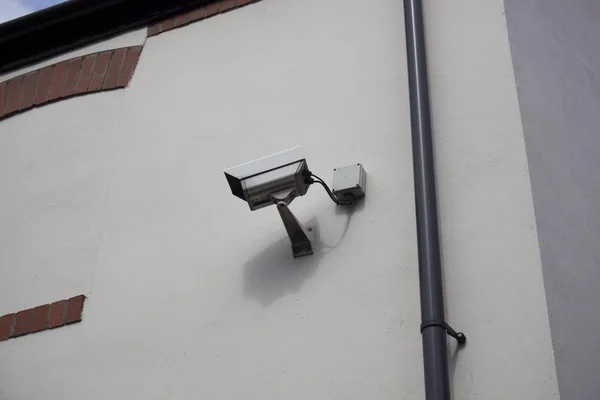 Überwachungskamera an weißer Wand montiert Stockbild