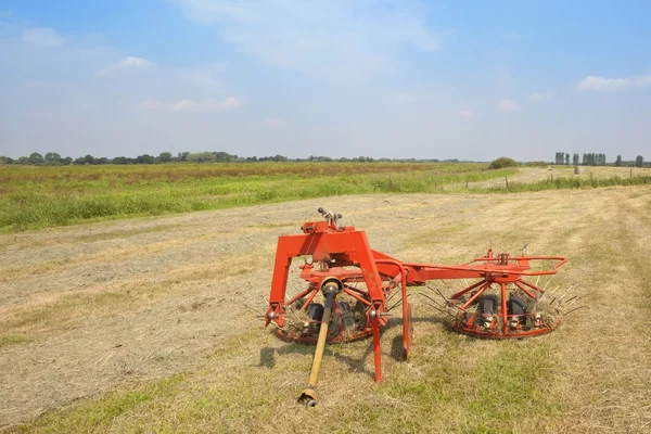 Landscape with hay turning equipment — Stock Photo, Image