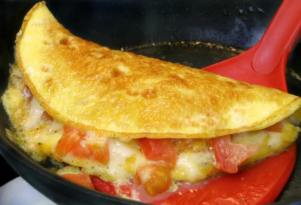 Omlet wird aus der Pfanne gehoben — Stockfoto