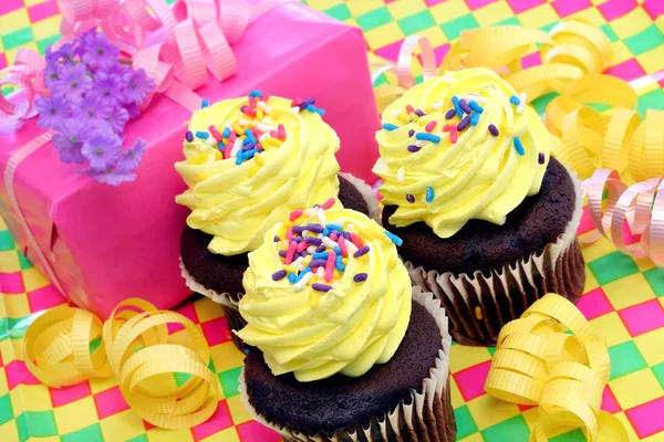 Yellow frosted cupcakes with birthday gift — Stok fotoğraf