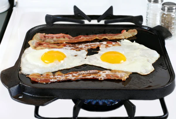 Huevos y tocino fritos en sartén de hierro fundido — Foto de Stock