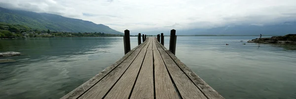 The wooden pier for boats and yachts on the background of the lake water — Stock Photo, Image
