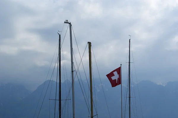 Drapeau de la Suisse sur le mât du yacht contre le ciel — Photo