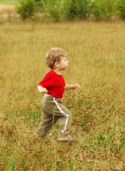 Chico corre en un prado . —  Fotos de Stock