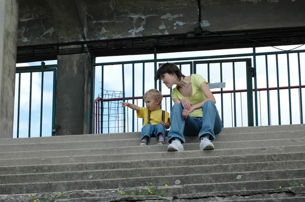 Matka i dziecko siedzieć na schodach. — Zdjęcie stockowe