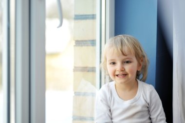 Girl sits at window clipart