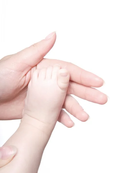 Babyfuß in der Hand der Mutter — Stockfoto