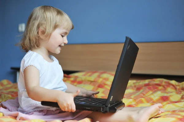 Pieni tyttö kannettavan tietokoneen kanssa — kuvapankkivalokuva