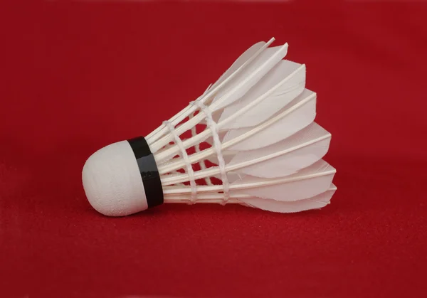 En vit badmintonbollen isolerad på röd — Stockfoto