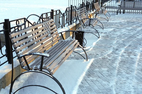 Скамейки в зимнем парке в городе — стоковое фото